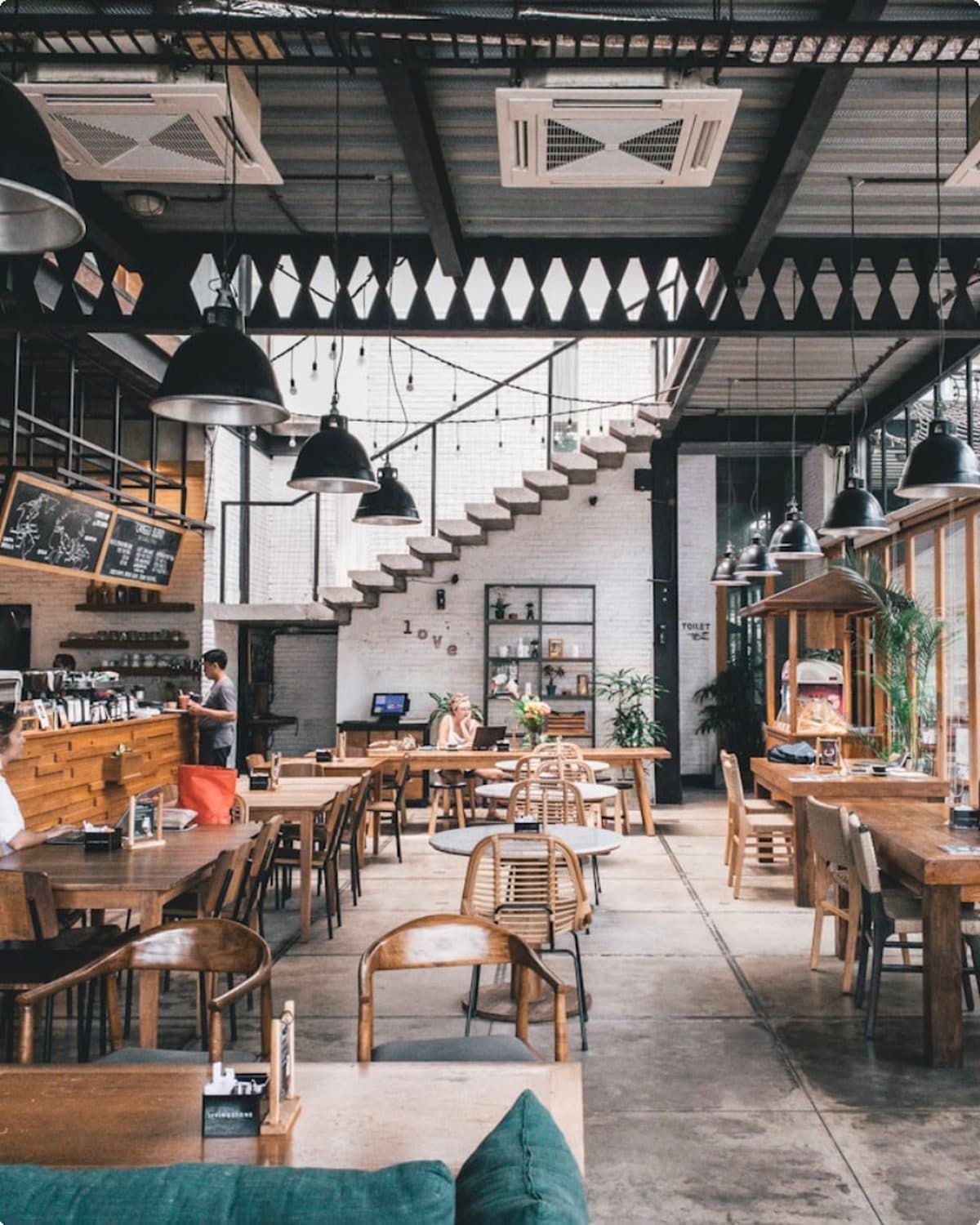 La salle du 52, ses grandes tables en bois et sa verrière